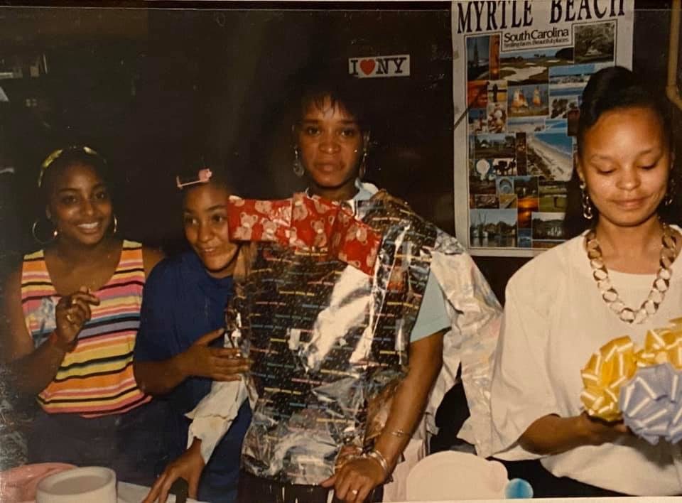 Sonya and friends at a party, one friend wrapped in gift paper