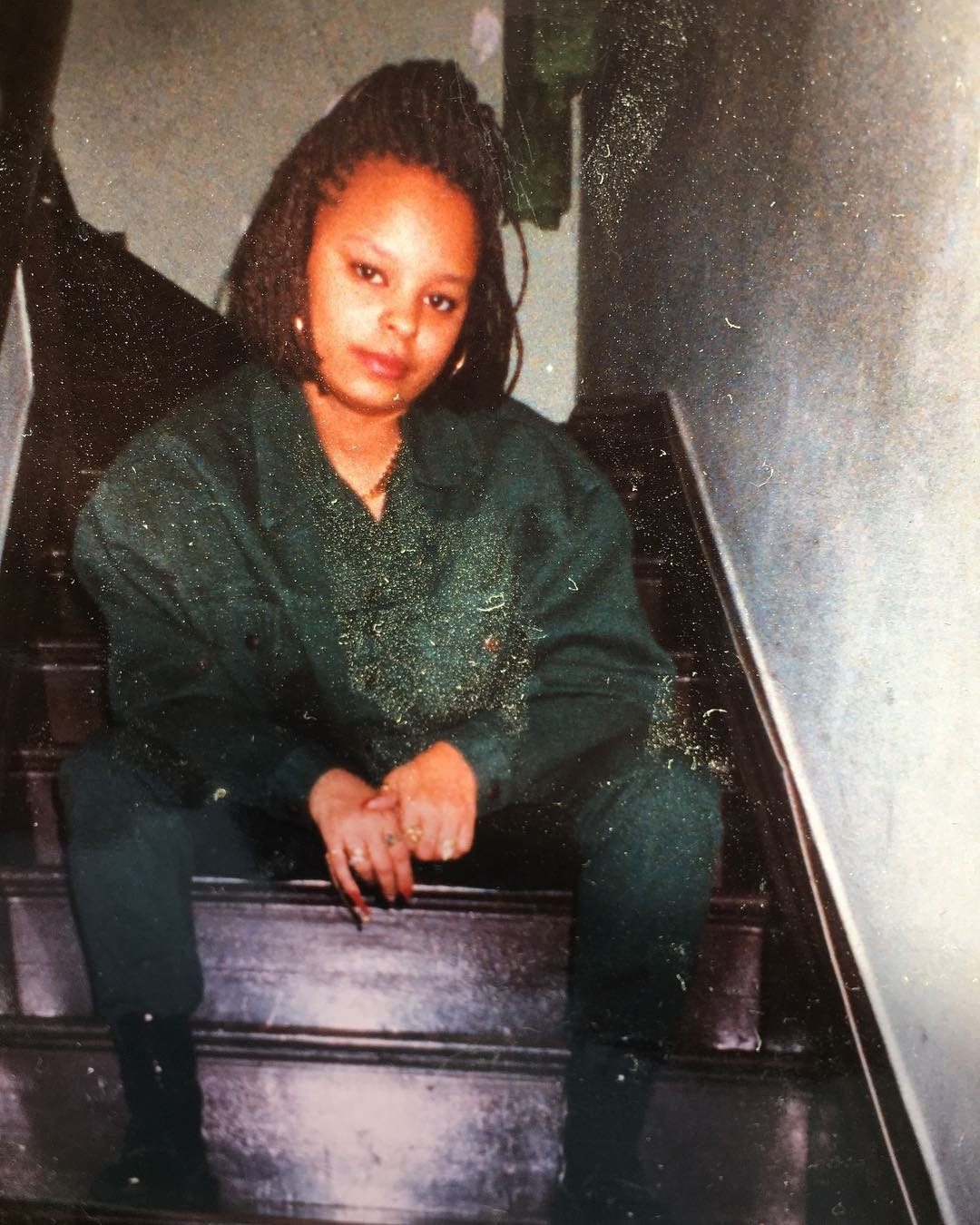Sonya sitting on a staircase in a green outfit