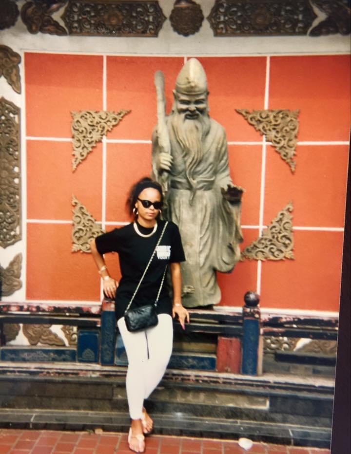 Sonya in sunglasses posing in front of a large statue